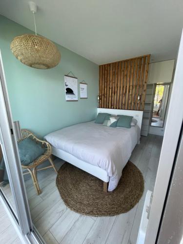 1 dormitorio con 1 cama grande y 1 silla en Appartement de standing, vue sur port de plaisance en La Baule