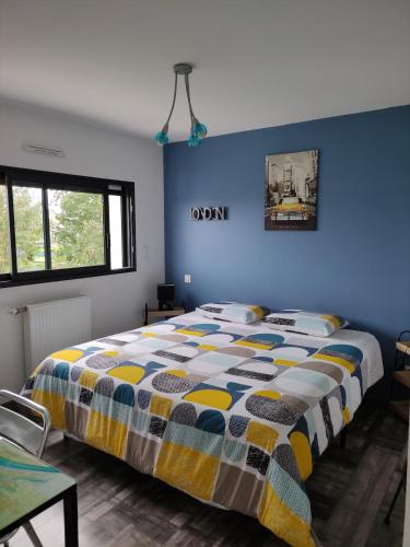 um quarto com uma cama e uma parede azul em Locabreizh 22 em Plourivo