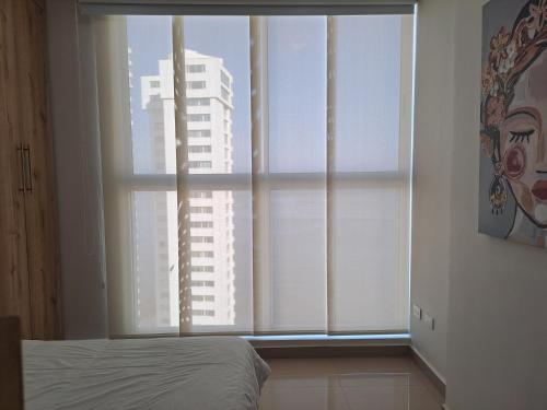 a bedroom with a window with a view of a building at Apartamento frente al mar Rodadero Santa Marta in Santa Marta