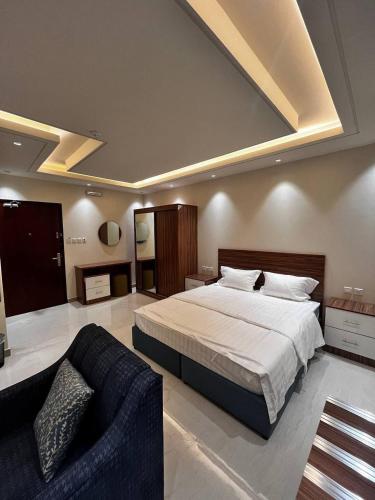 a large bedroom with a bed and a couch at سجى الهدوء للشقق المخدومة in Abha