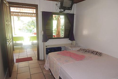a bedroom with a bed and a room with a window at Pousada Cair do Sol in Ilha do Mel