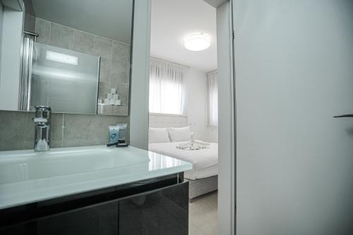 a bathroom with a tub and a sink and a bed at Royal Park By Sun and View in Eilat