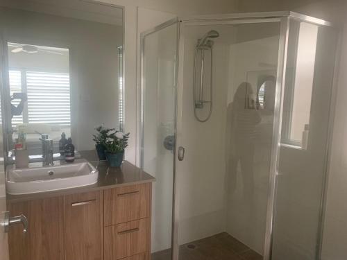 a bathroom with a shower and a sink and a mirror at Huntlee Getaway in Branxton