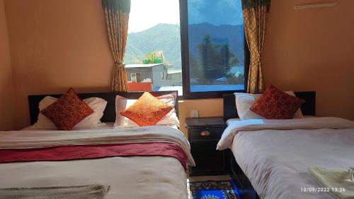 Un dormitorio con dos camas con almohadas encima. en The Eagle Zone, en Pokhara