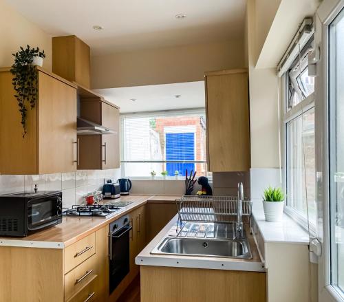 a kitchen with a sink and a microwave at The Warwick - Quaint Victorian Home With Free Parking in York