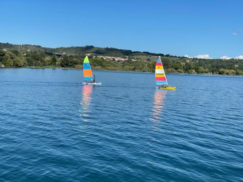 two small sailboats on a large body of water at VILLA "Lago Blu" vista lago di Bracciano, con vasca idromassaggio esterna in Trevignano Romano