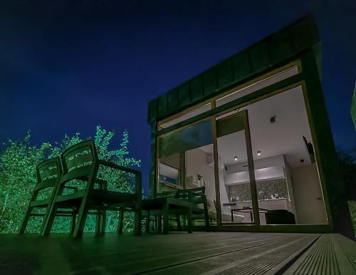 a group of chairs sitting on a deck at night at Domki Platan w Karkonoszach in Kowary