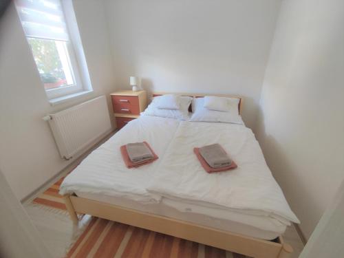 1 dormitorio con 1 cama con 2 toallas en BlankApartman en Mohács