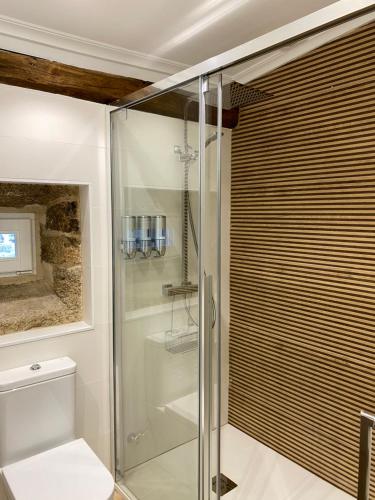 a bathroom with a glass shower with a toilet at Celanova House in Celanova