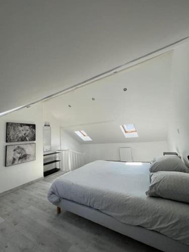 - une chambre blanche avec un grand lit et des lucarnes dans l'établissement L'amiénoise proche zenith stade cathédrale, à Amiens