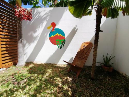 a wall with a chicken painted on it next to a chair at Le Langka in Saint-Louis