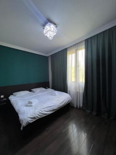 a bedroom with a white bed and a chandelier at Monte Bianco in Mestia
