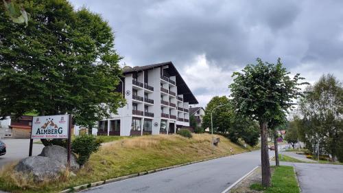 a building on a hill next to a street at Two Apartaments Almberg - Mitterdorf-Mitterfirmiansreut in Mitterfirmiansreut