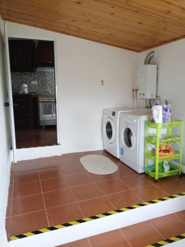 a kitchen with a washing machine on a tiled floor at Casa do Lajedo in Porto Martins