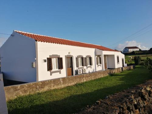 a white house with a wall at Casa do Lajedo in Porto Martins
