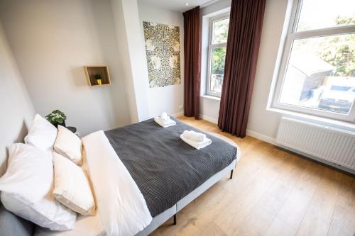 a bedroom with a bed and two windows at Quality 2 Bedroom Serviced Apartment 72m2 -VP2A- in Rotterdam