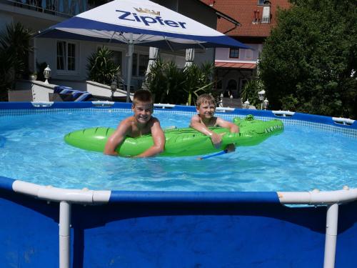 Dwóch chłopców jest w basenie w nadmuchiwanym w obiekcie Landgasthof Spitzerwirt w mieście St. Georgen im Attergau