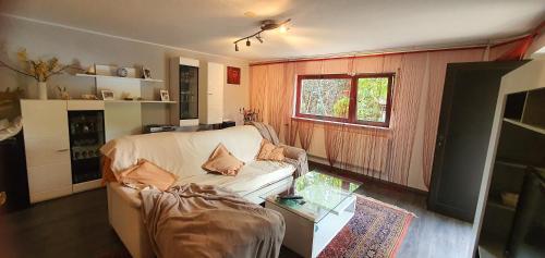 a living room with a couch and a window at Schöne Ferienwohnung mit Terrasse und Garten in Überherrn