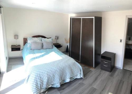 ein Schlafzimmer mit einem großen Bett und einer Kommode in der Unterkunft Olivo Apartment in Esquel