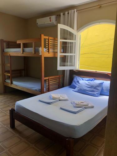 a bedroom with a bed with two bunk beds at O Mar Hospedagem - SUÍTES PRIVADAS in Arraial do Cabo