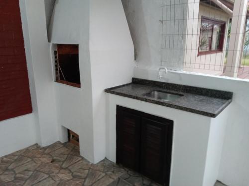 a kitchen with a sink and a fireplace at Casa da Cal in Torres