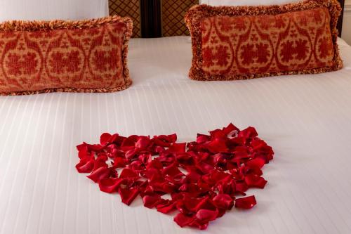 a heart made out of red roses on a bed at Ermitage - Mont-Saint-Michel in Beauvoir