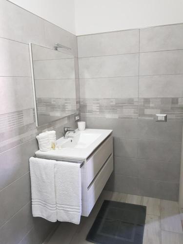 a white bathroom with a sink and a mirror at Appartamento nuovo in Lampedusa