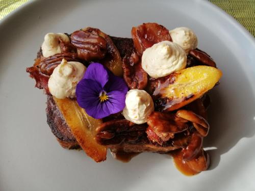 a plate of waffles with a purple flower on it at Hartford House in Mooirivier
