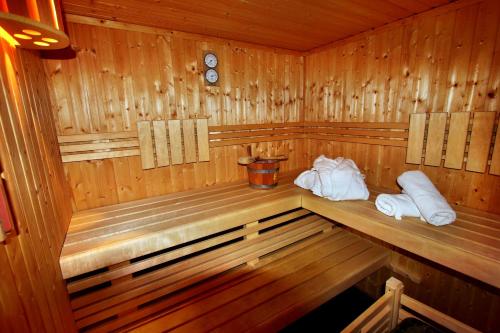 a wooden sauna with two white towels in it at Luxusferienhaus Seevilla Monaco am Fleesensee in Göhren-Lebbin