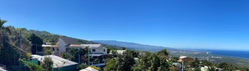 a town on a hill next to the ocean at La kaz tifi in Les Avirons