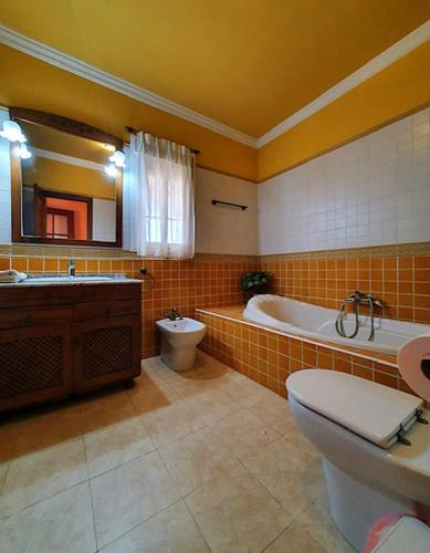 a bathroom with a tub and a toilet and a sink at casa frami in Conil de la Frontera