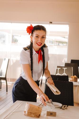 a woman is preparing food on a table at Hotel Giulia in Lido di Camaiore