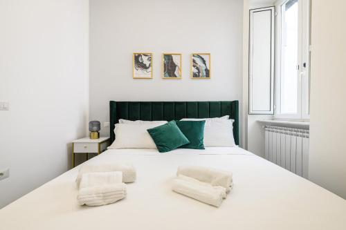 sypialnia z dużym białym łóżkiem z zielonymi akcentami w obiekcie Magical Botanic-Charming Apartment w mieście Neapol