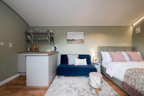 a bedroom with a bed and a blue chair at Barfield Shepherds Hut in Magherafelt