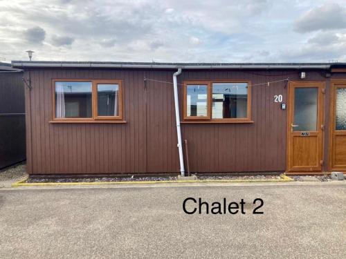 a brown building with two windows and a door at Atlanta Ceder Wood Chalet in Mablethorpe