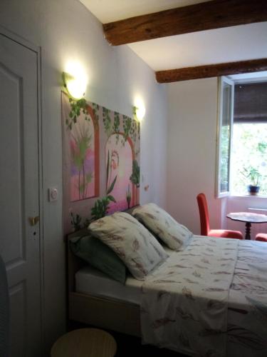 une chambre avec un lit, une table et une fenêtre dans l'établissement Les Abeilles, à Signes