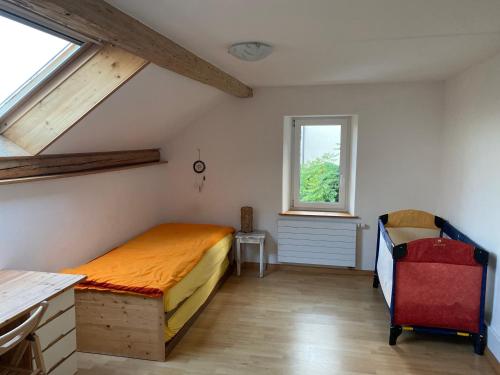 a bedroom with a bed and a desk and a window at A la Maladière in Neuchâtel