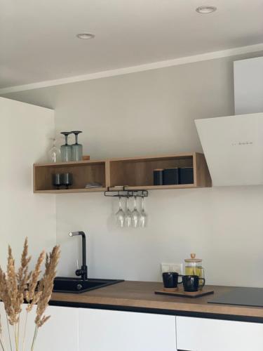 a kitchen with white cabinets and a counter top at Divas Laivas apartments with a terrace in Ķesterciems