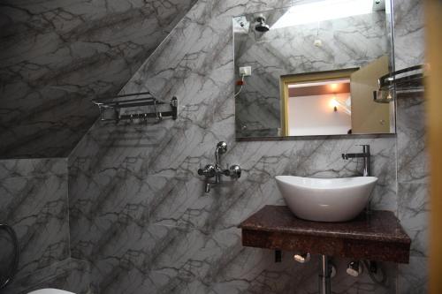 a bathroom with a sink and a mirror at PHIBHA VILLA in Shillong