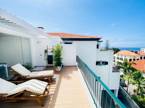 uma varanda com cadeiras e vista para o oceano em Madeira Precious Penthouse no Funchal