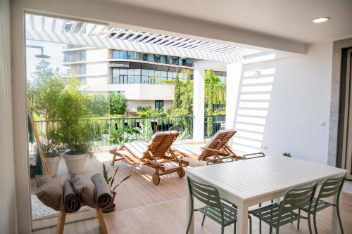 un patio con una mesa blanca y sillas en Madeira Precious Penthouse en Funchal