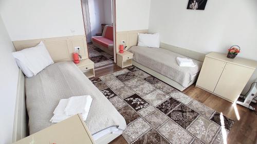 a small room with two beds and a mirror at VILA ONIX in Săcueni