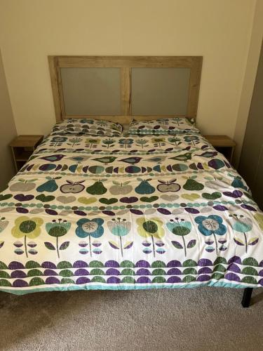 a bed with a quilt on top of it at 709 Seawick in Jaywick Sands