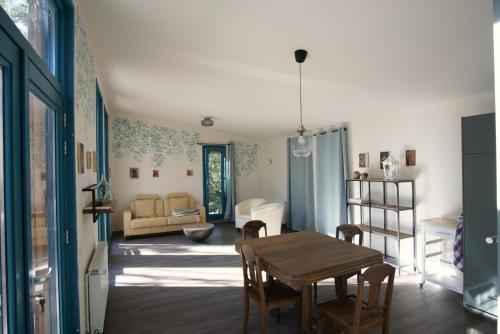 a living room with a table and chairs and a couch at Le Nid d'Écureuil in Épiry