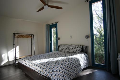 a bedroom with a bed and a large window at Le Nid d'Écureuil in Épiry