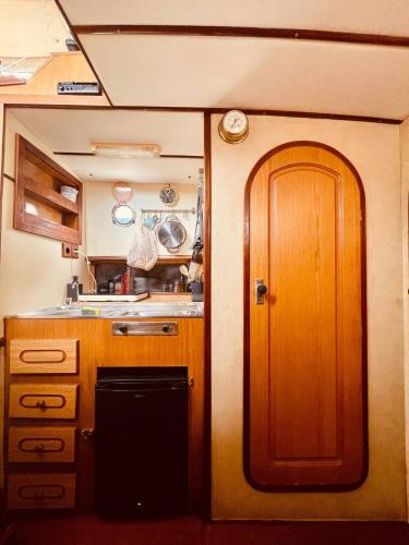 eine Küche mit einer Holztür und einem Waschbecken in der Unterkunft Stylish 80´s Fishing Boat in Barcelona