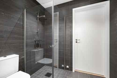 a bathroom with a shower with a toilet and a glass door at Apartment in Frogner Lillestrøm - Modern and Central in Lillestrøm