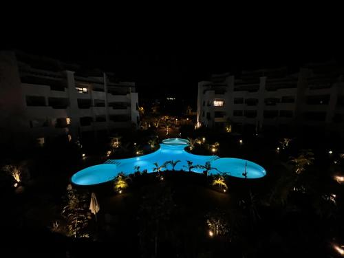 una gran piscina en medio de un edificio por la noche en Cozy apartment with pools in Palm Mar en El Palmar