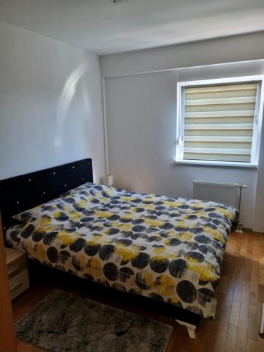 1 dormitorio con 1 cama con edredón amarillo y azul en Apartman Court Prijedor, en Prijedor