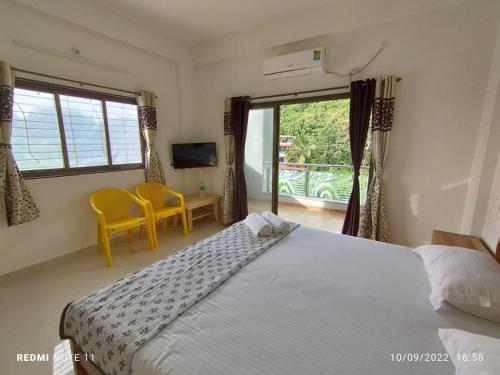 a bedroom with a large bed and a window at Hotel Kavijay Sea View in Dapoli